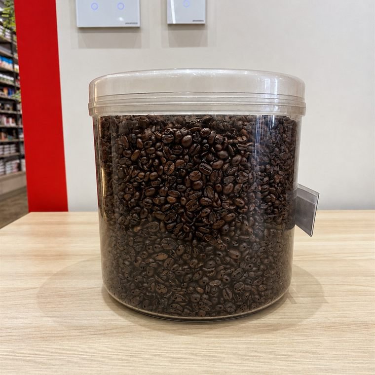 Pote de café em grãos sobre a bancada da loja